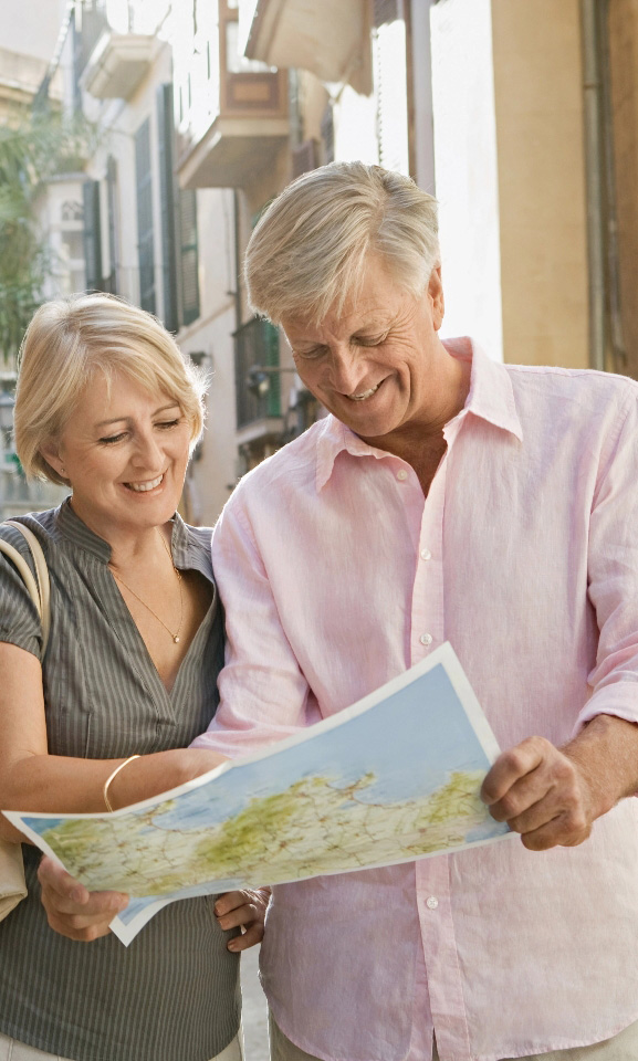 Happy retired couple travelling looking at map