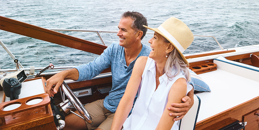 Middle aged couple cruising on boat tablet
