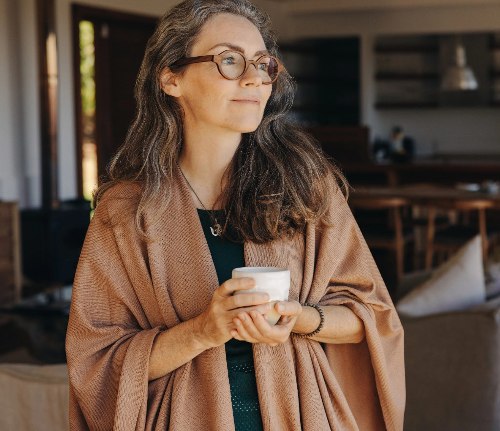 Middle aged woman looking out window tablet