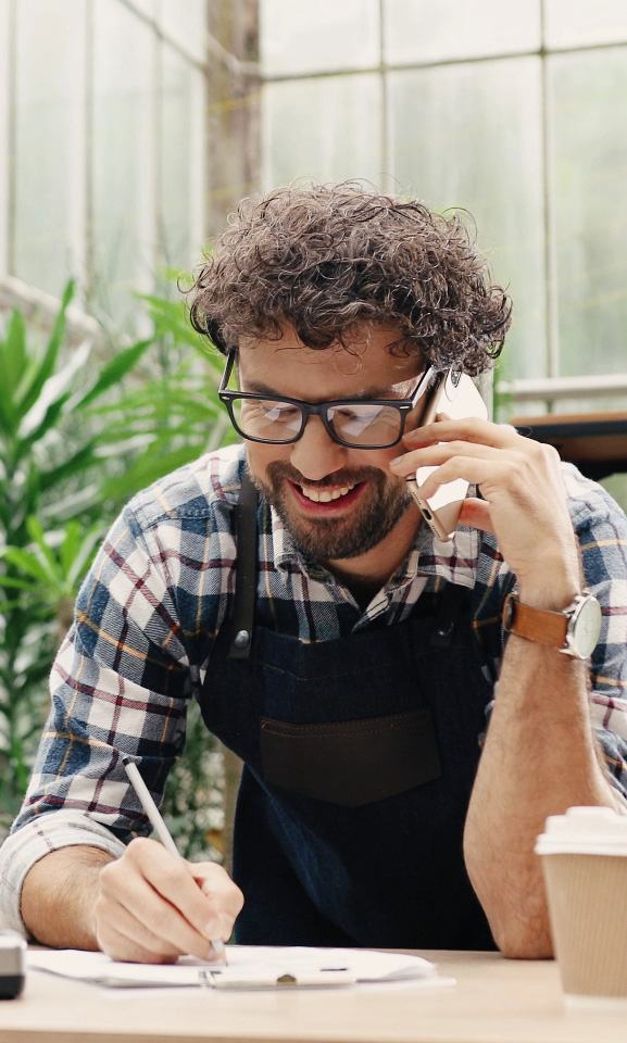 Business owner smiling talking with customer on phone