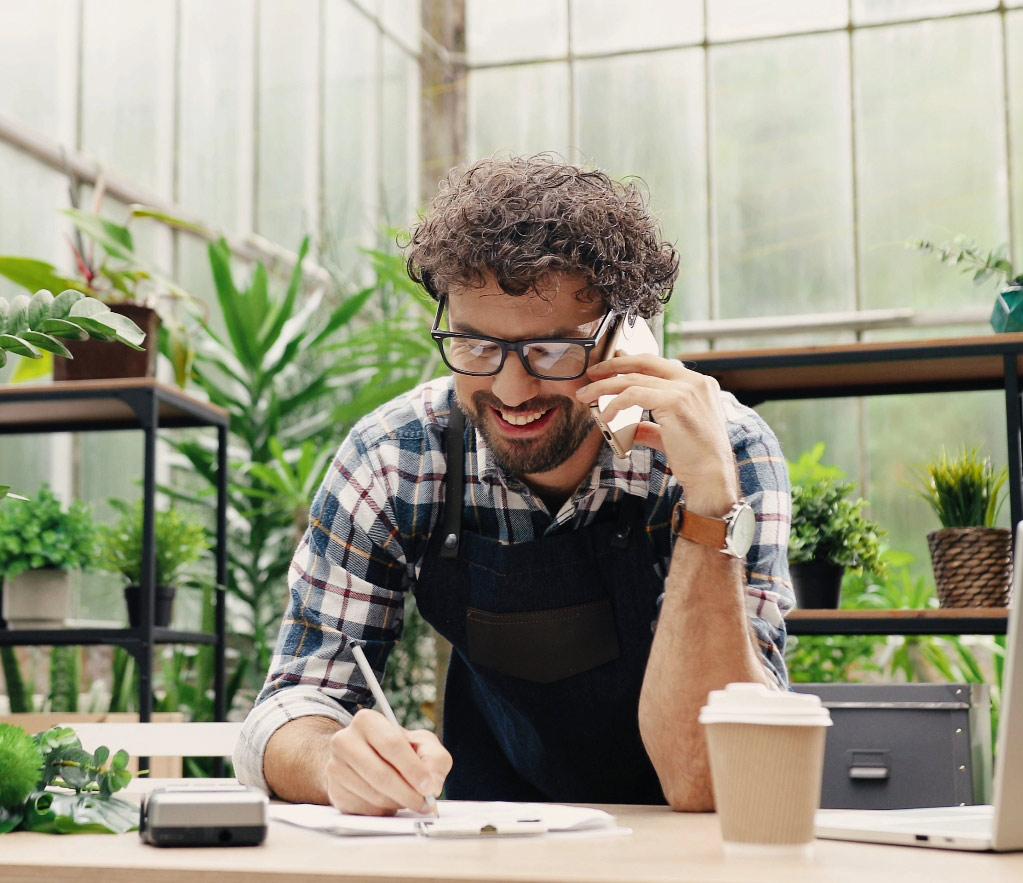 Business owner smiling talking with customer on phone tablet