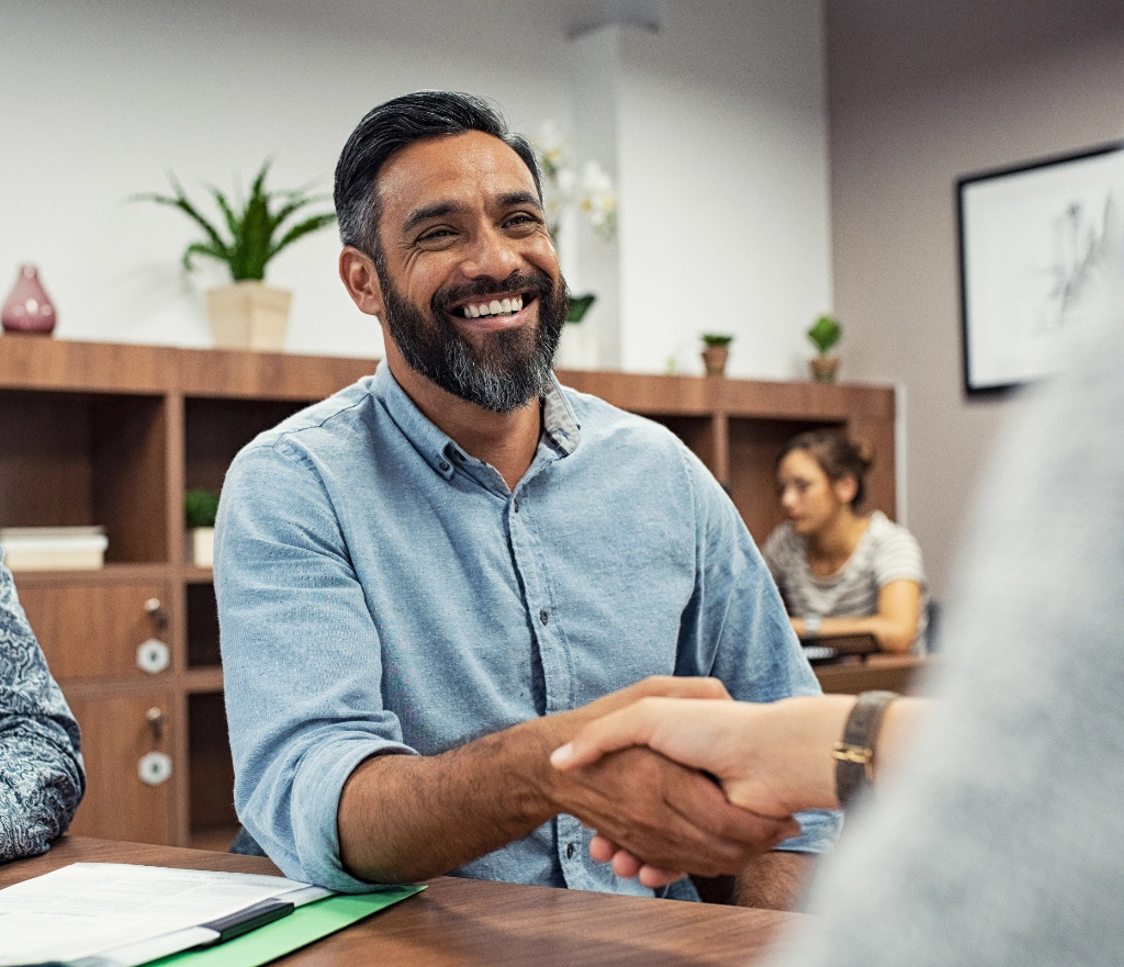 Middle aged man shaking hands with advisor tablet