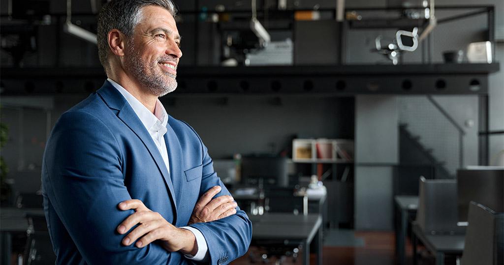 Successful business man with arms folded tablet